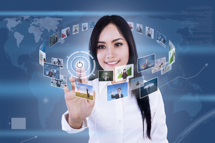Beautiful woman is clicking on touch screen to choose digital photos
